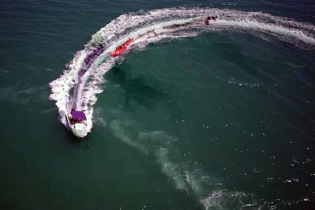 Vuelo de evento deportivo y audiovisual con dron sobre el mar. Evento acuático en la playa con un dron