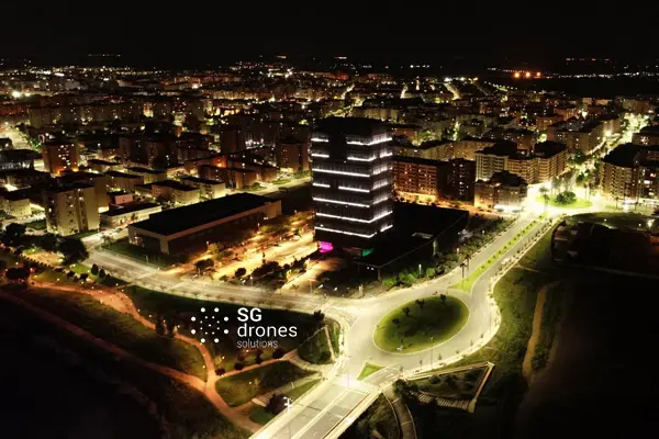 Imagen de Vuelo nocturno dron Badajoz edificio siglo xxi iluminado utilizada en los servicios profesionales de SG Solutions.